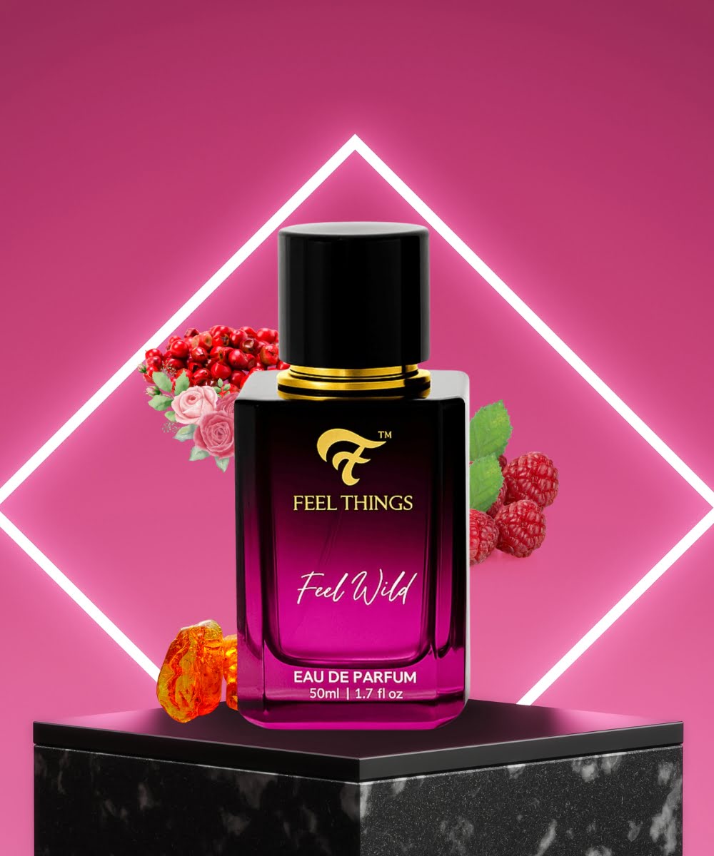 feelthings Perfume bottle labeled 'Feel Things Feel Wild' on a pink background with decorative notes raspberry ,amber,strawberry and floral.