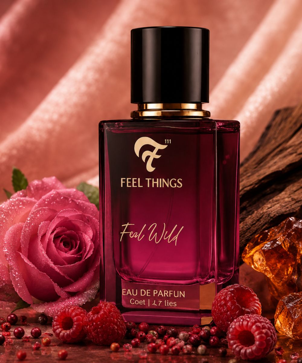 feel wild Perfume bottle labeled 'Feel Things' with a pink rose and raspberries on a wooden surface.