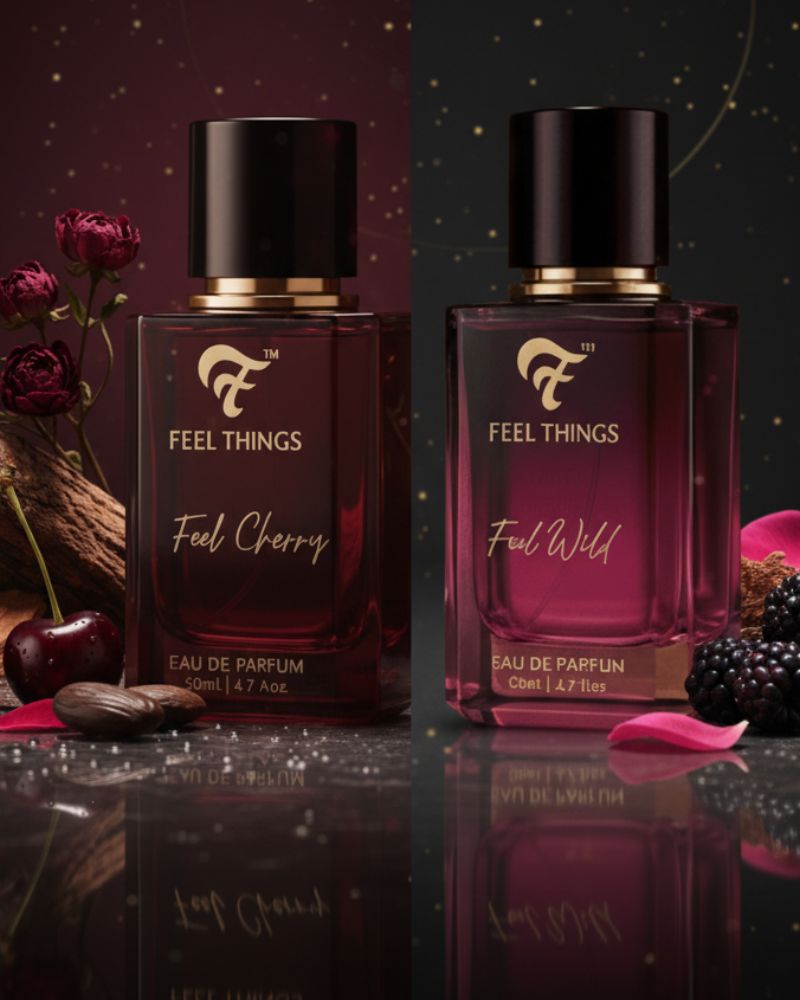 Two bottles of 'Feel Things' perfume with cherry and blackberry elements on a dark background.